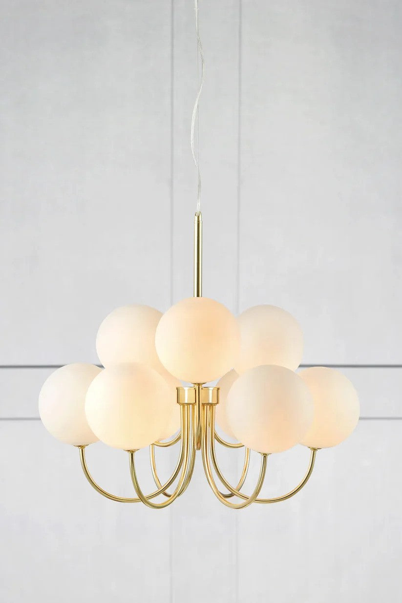 Zoomet helt tæt på Bianco Pendel 9L i Guld/Hvid hængt op foran en væg for den flotte kontrast