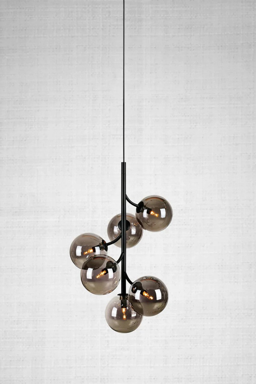 Callisto Pendel 6L i Sort/Røg hængt op foran væggen for en flot kontrast af den elegante pendel