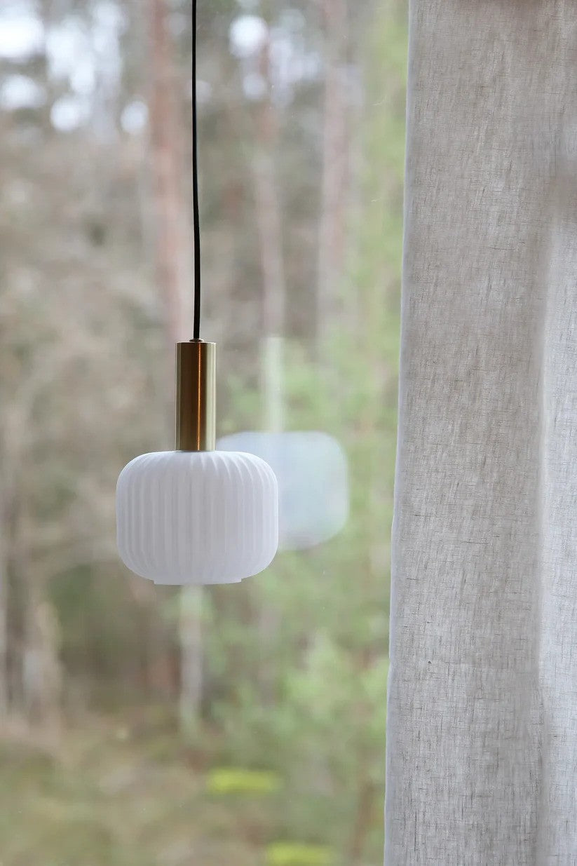 Sober Pendel i Messing/Hvid hængt op foran vinduet for det æstetiske design