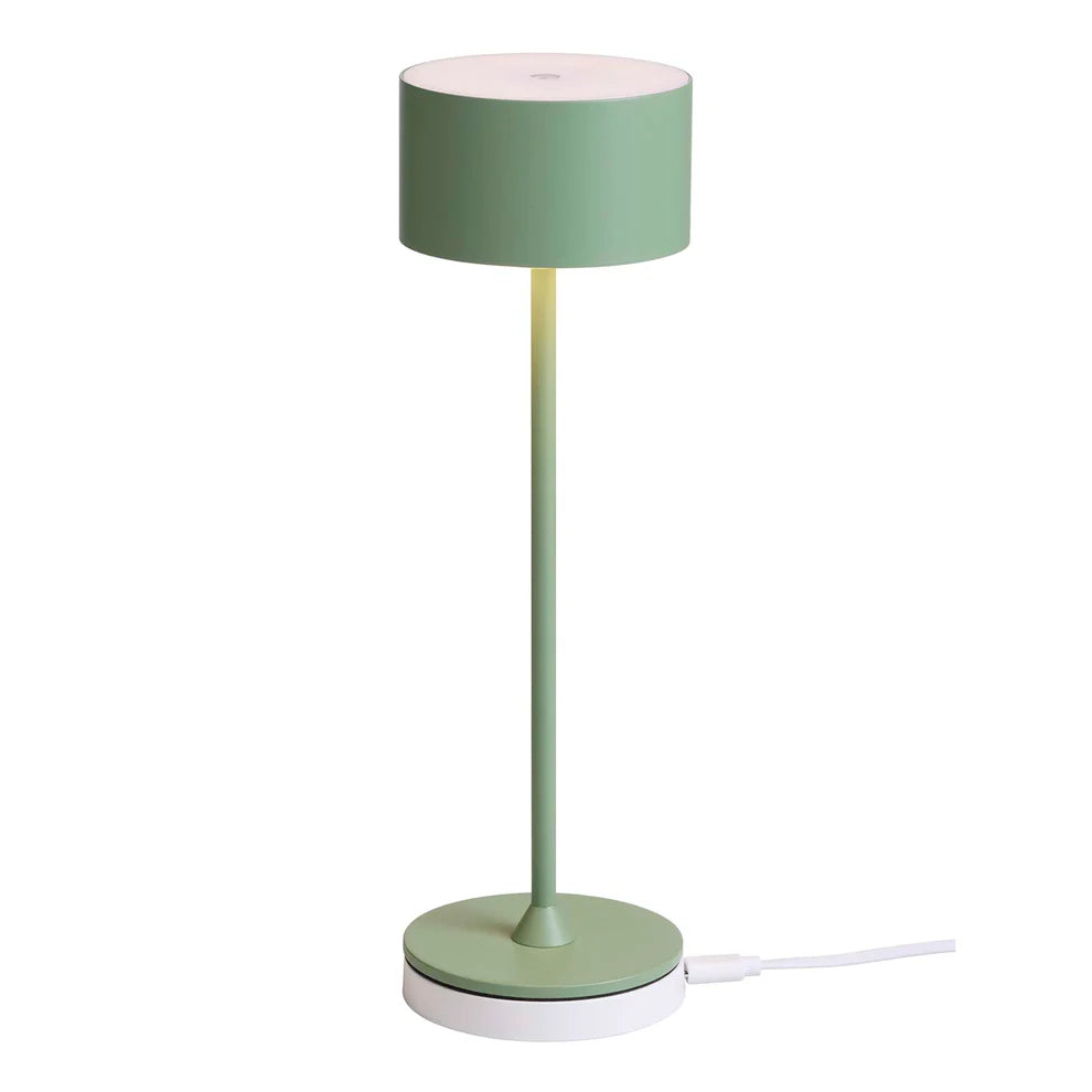 Den unikke designet Bistro LED Bordlampe i Støvet Grøn placeret på dens lade station