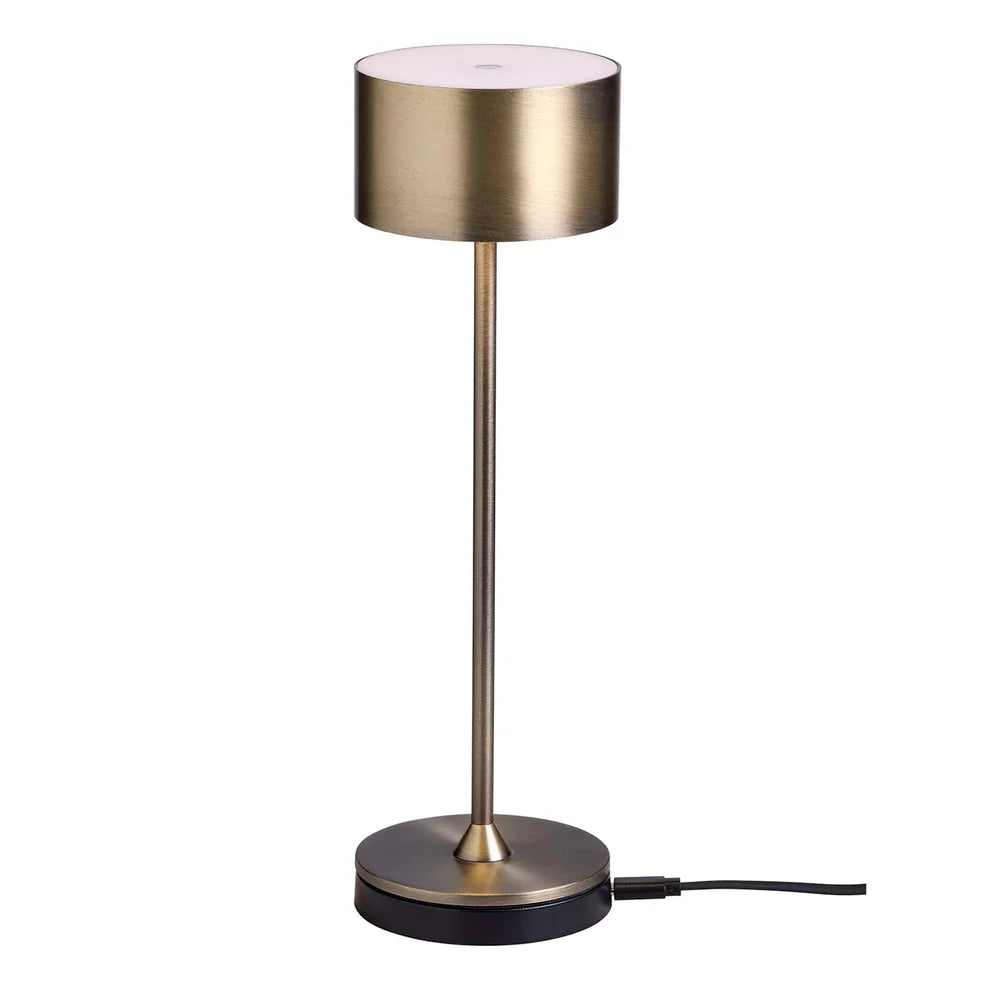 Den unikke designet Bistro LED Bordlampe i Antik Børstet Messing placeret på sin lade station