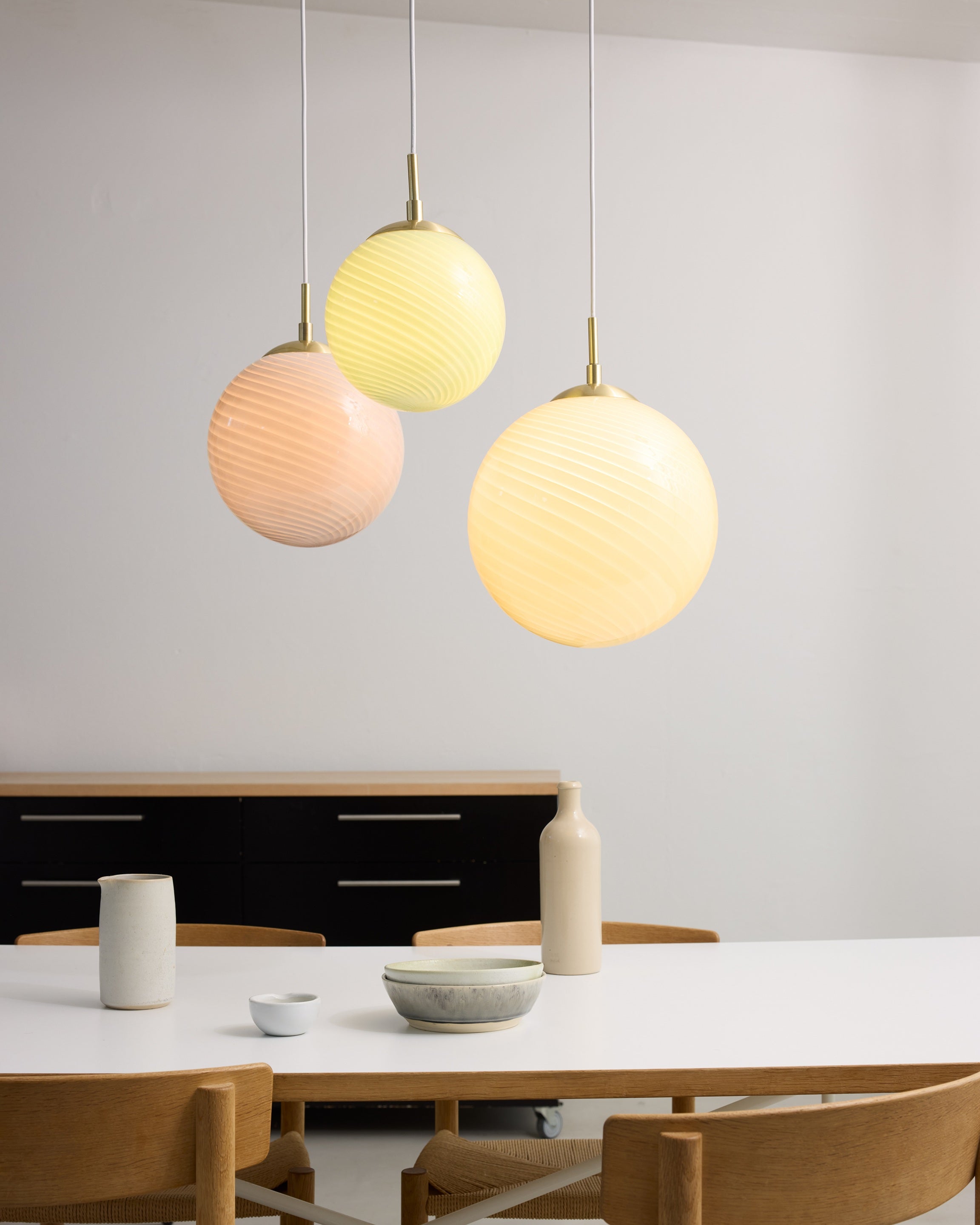 Den elegante designet Candy Ball Pendel Ø30 i Cream hængt op over spisebordet for dens varme belysning