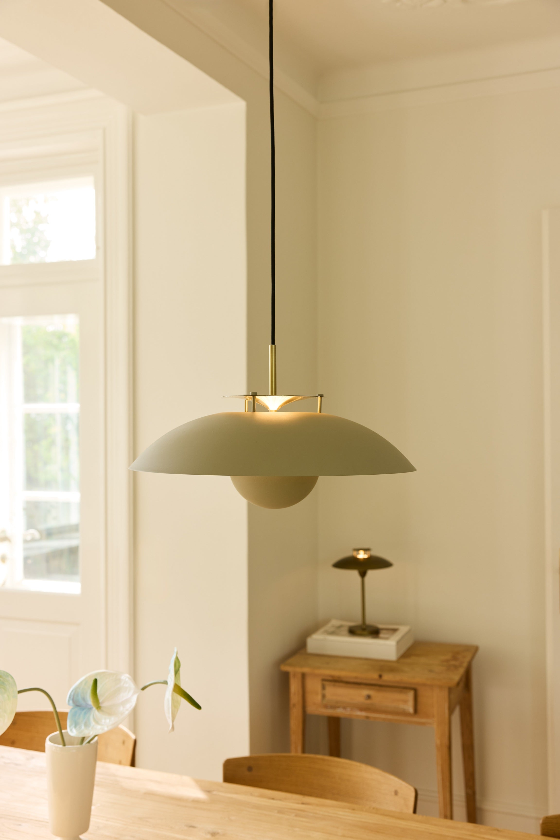 Zoomet ind på den æstetiske Stepp Pendel Ø46 i Sand/Antique placeret over spisebordet for dens varme belysning