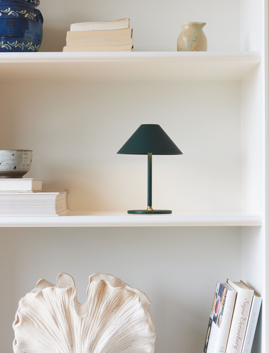 Grøn Halo Design portable lampe i en hvid reol