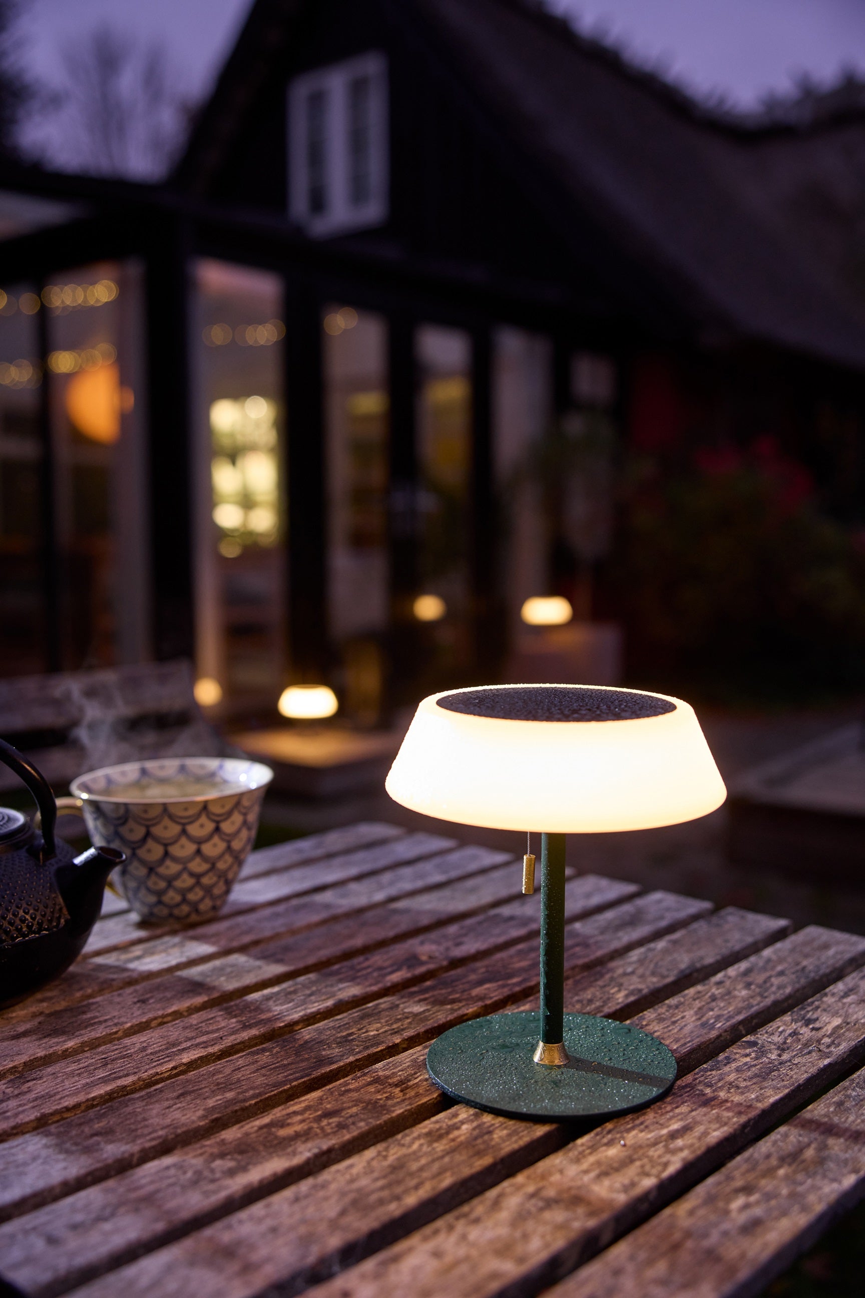Halo Design Solar Portable Table Lamp udenfor i Dark Green