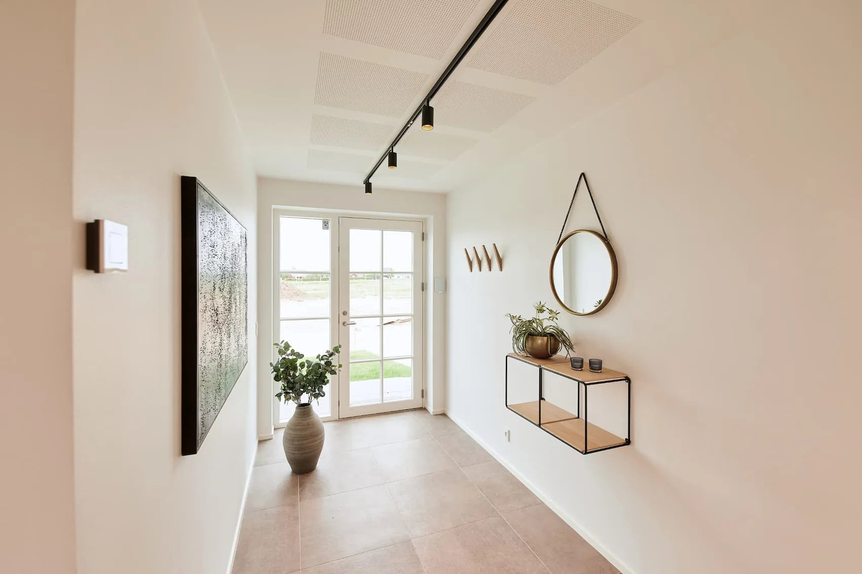 Den elegante designet Designline Tube Pro Spot i Grib Sort hængt op i gangen for dens varme belysning