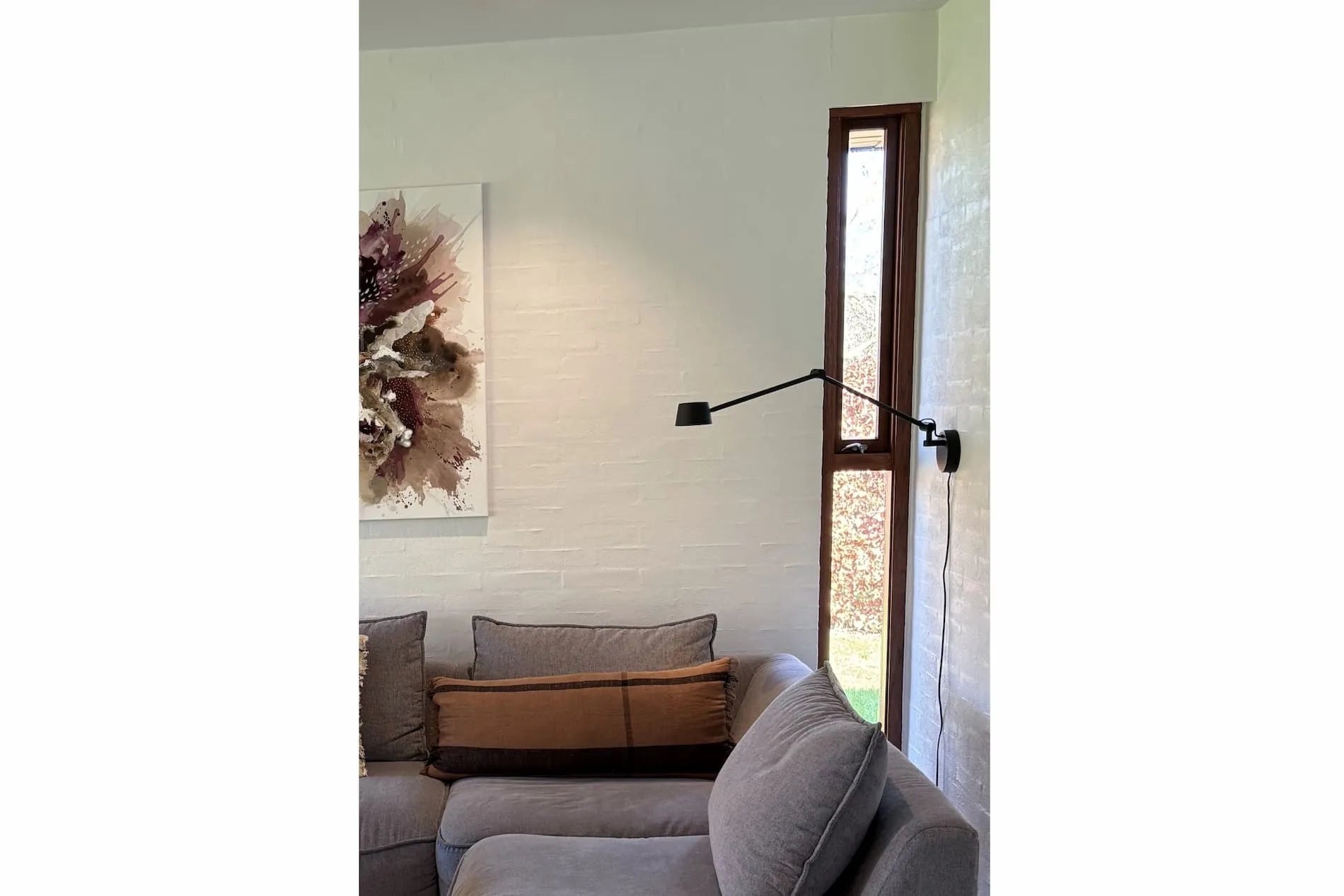 Direction Wall sort LED væglampe over sofaen