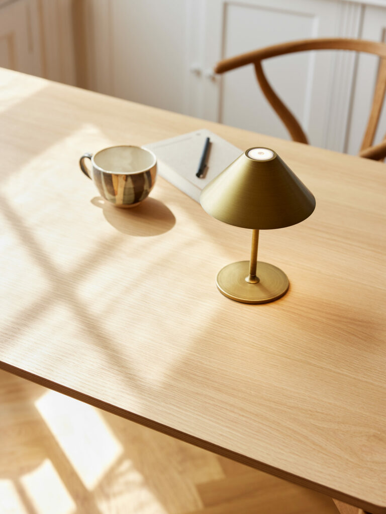 Flot Halo Design portable lampe i messing på et træbord