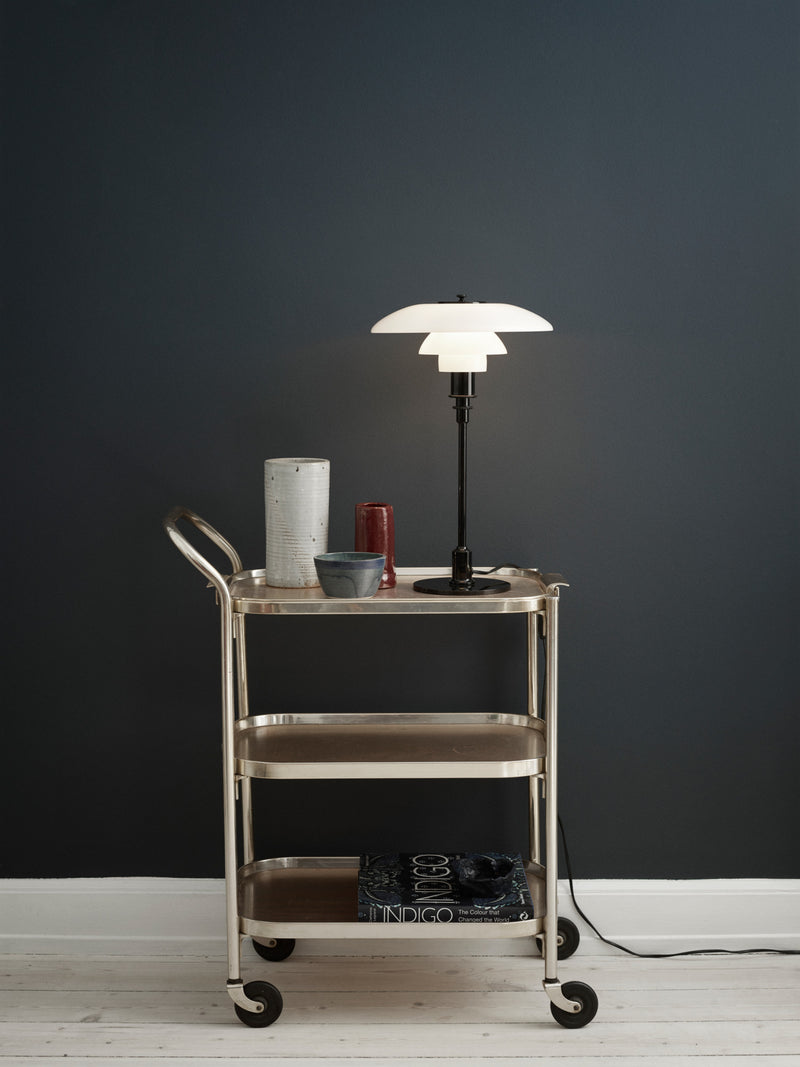 Den populære PH lampe 3/2 på et rullebord i en stue med trægulv