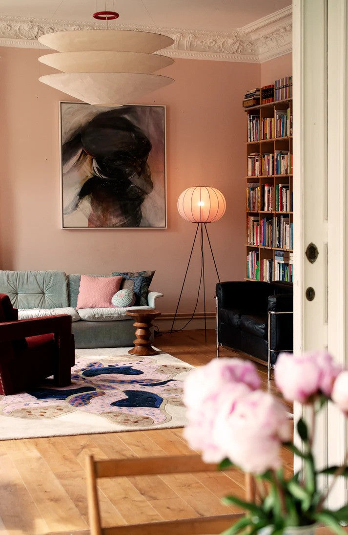 Den æstetiske Knit-Wit Ø45 Round Gulvlampe High i Light Pink sat i hjørnet af stuen ved siden af sofaen for en behagelige og varm belysning