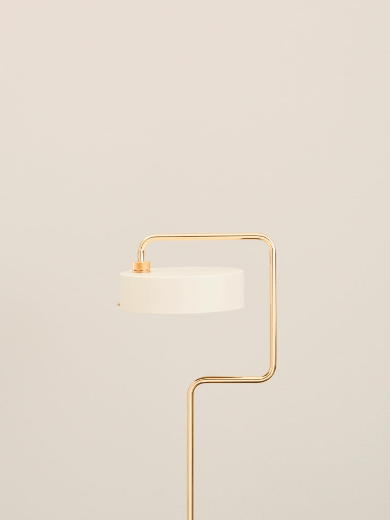 Zoomet ind på toppen af Petite Machine Gulvlampe i Hvid foran en væg med en flot kontrast