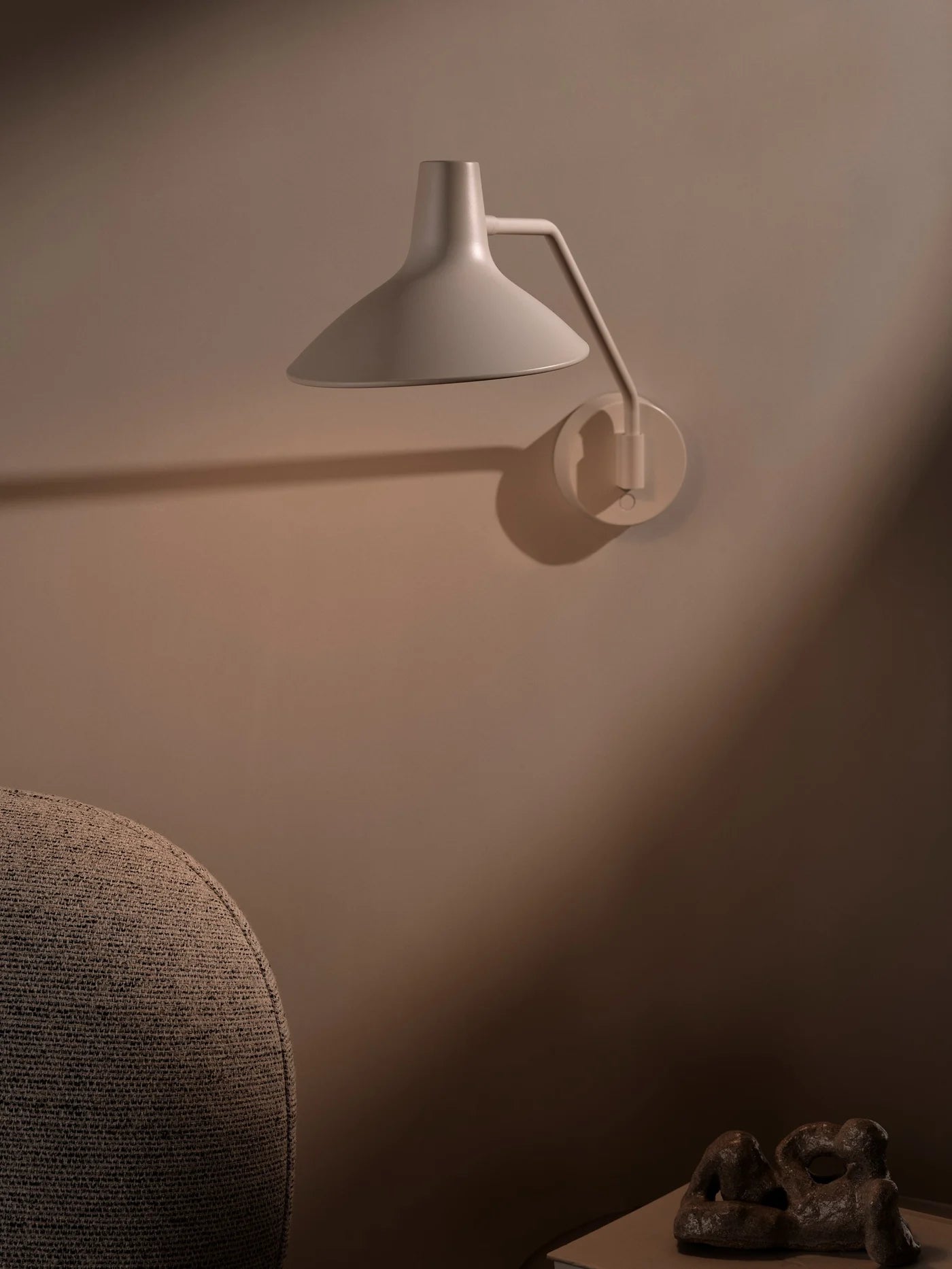 Zoomet helt ind på den unikke designet Darci Væglampe i Sandfarvet hængt op i stuen