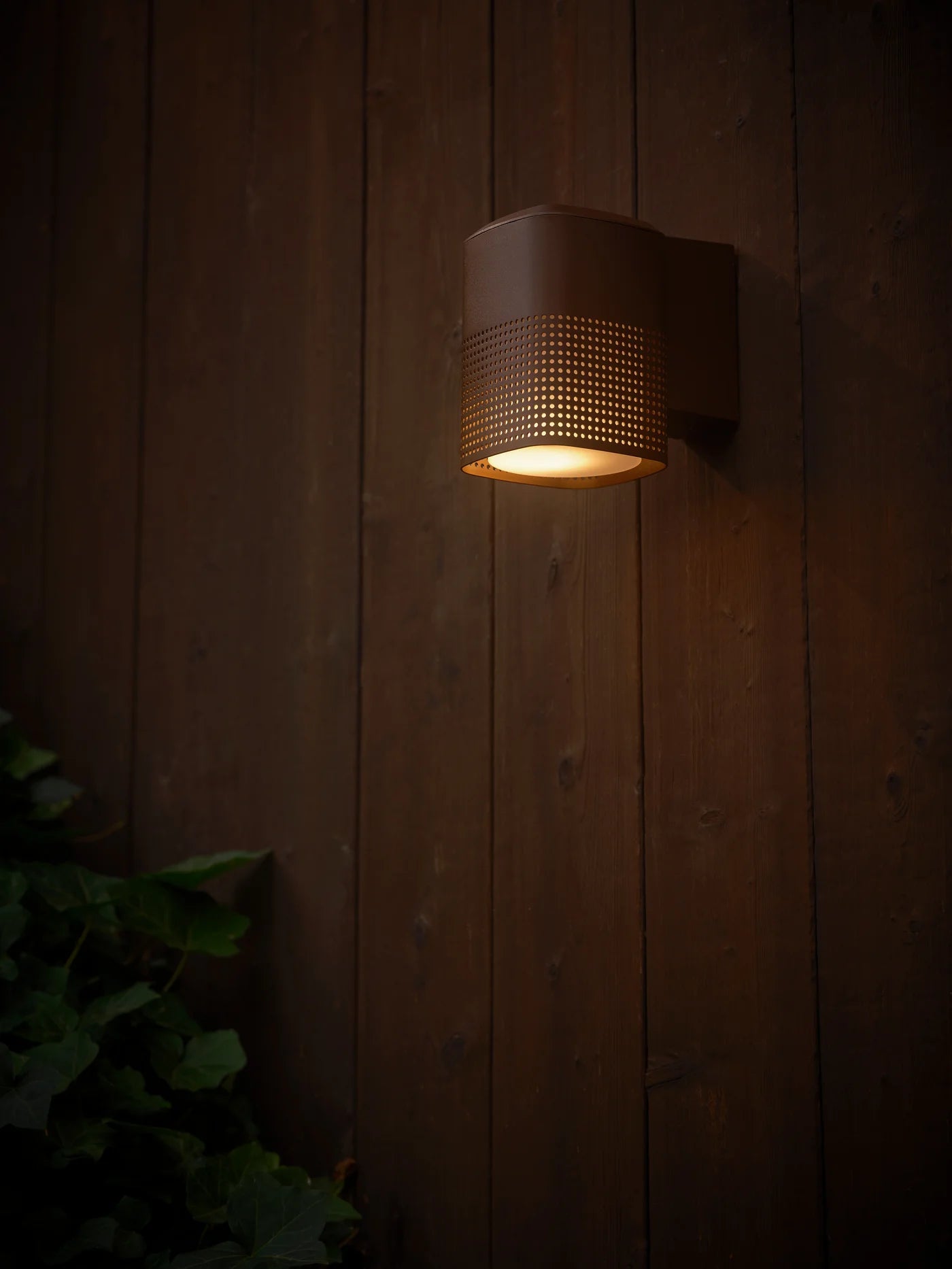 Zoomet ind på den unikke designet Sidara Væglampe Seaside i Metallisk Brun hængt op på væggen udenfor