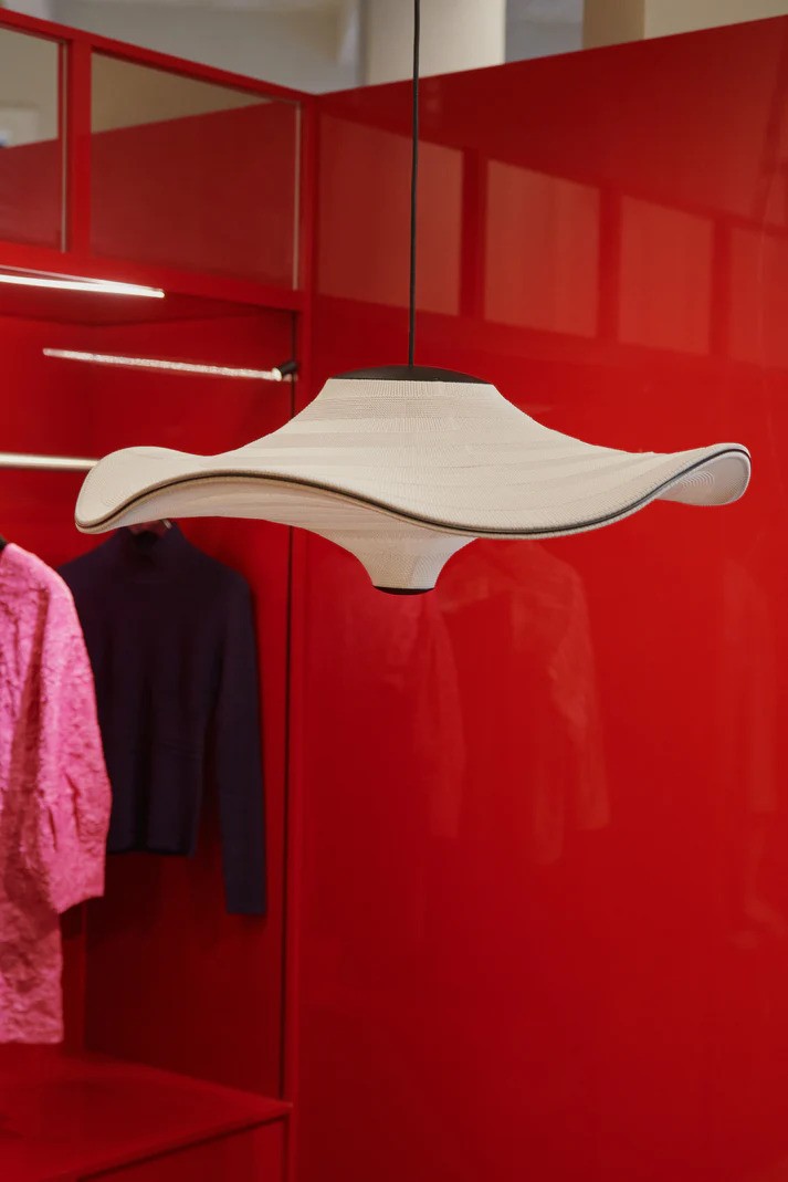 Den elegante og unikke Flying Ø58 i Ivory White hængt op i en tøjbutik