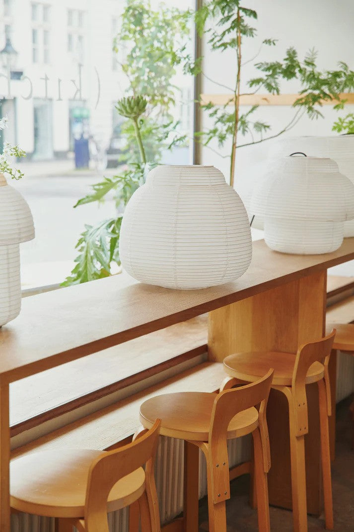 Den unikke designet Papier Single Ø40 Pendel i Hvid placeret på et aflangt bord