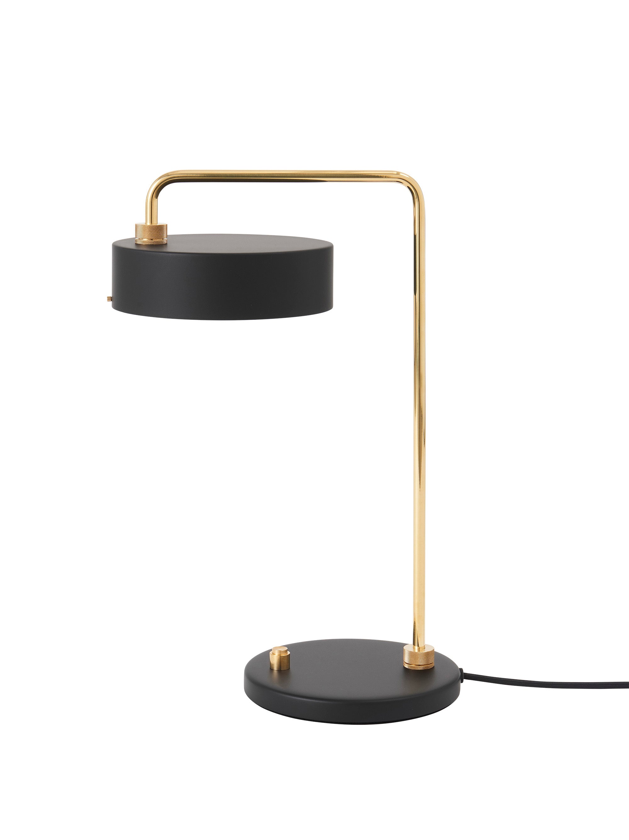 Den unikke designet Petite Machine Bordlampe i Sort placeret foran en hvid væg for den flotte kontrast