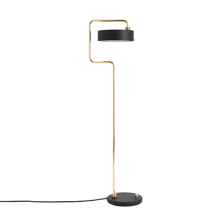 Den æstetiske Petite Machine Gulvlampe i Sort placeret foran en hvid væg for den flotte kontrast