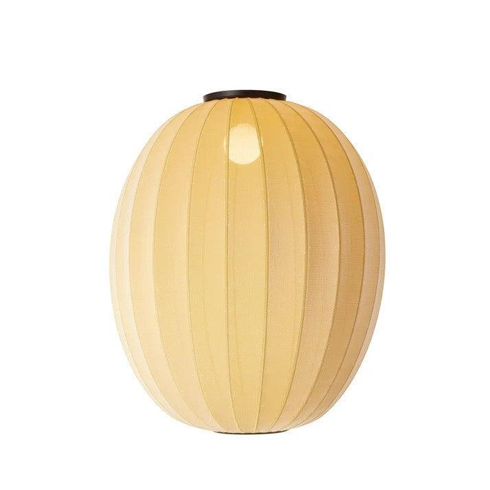 Den æstetiske Knit-Wit Ø65 High Oval Loftslampe i Sunrise hængt op foran en hvid væg med en E27 pære iført