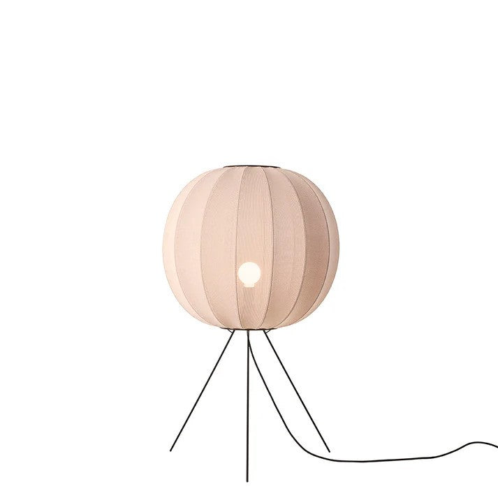 Den æstetiske Knit-Wit Ø60 Round Gulvlampe Medium i Sand Stone placeret foran en hvid væg med en E27 pære iført for den behagelige og varme belysning