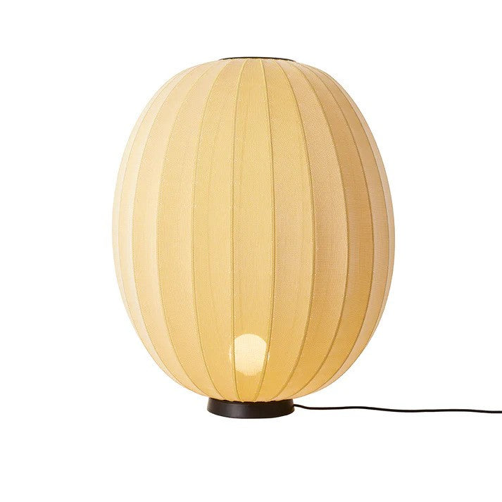 Den æstetiske Knit-Wit Ø65 High Oval Floor Level i Sunrise med en E27 pære iført for dens behagelige belysning