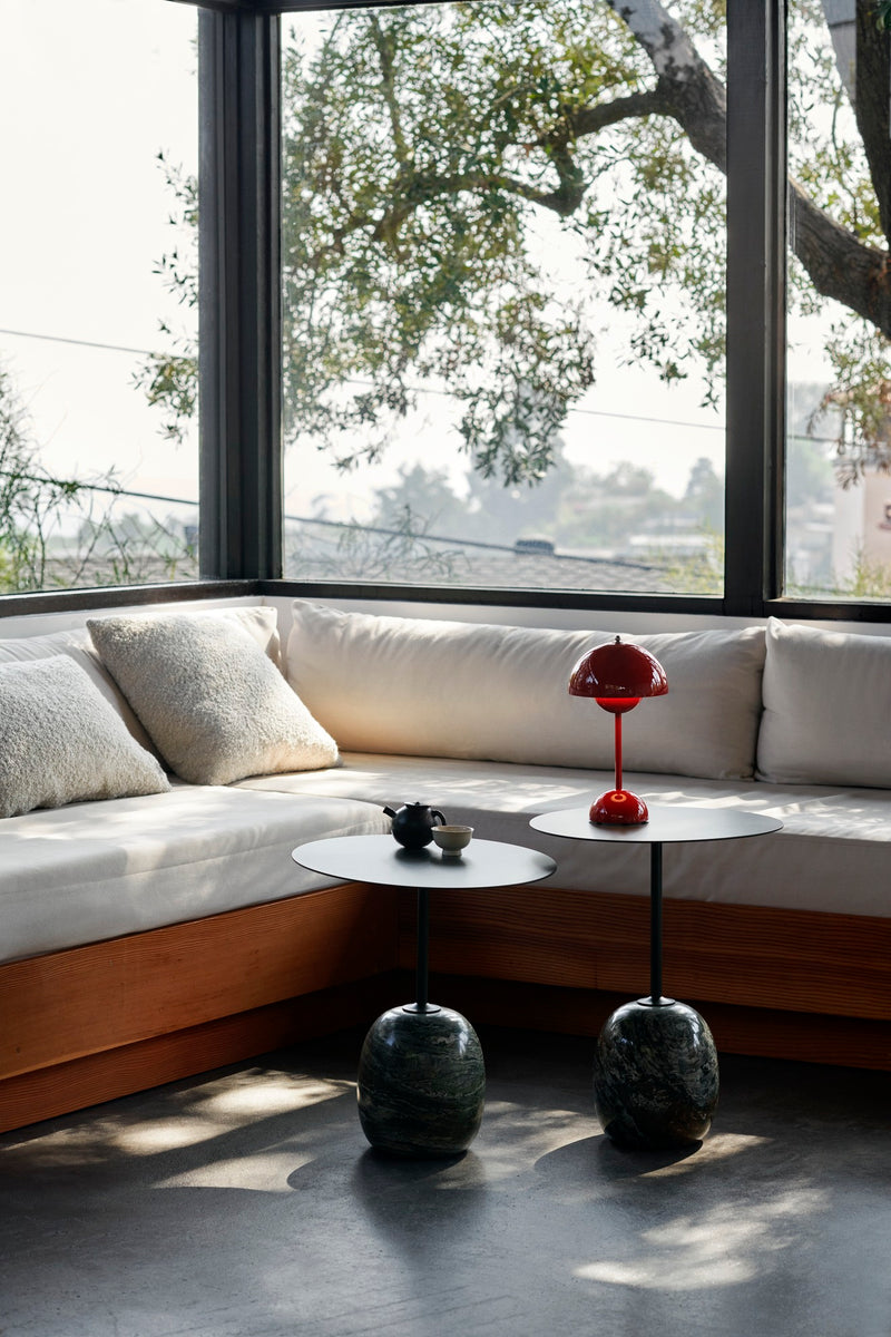 Den smarte røde Flowerpot bordlampe på et lille bord sammen med en sofa