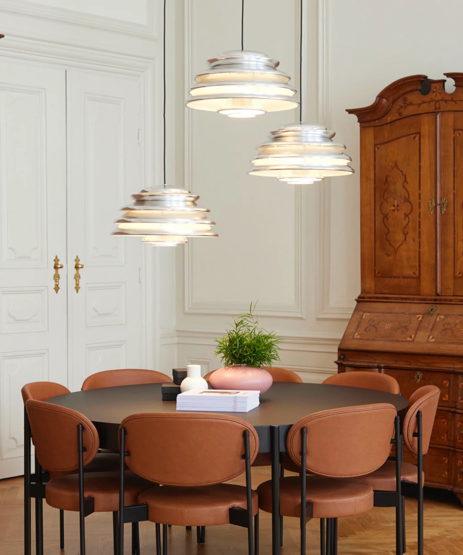 tre Hive pendel lamper over et rundt spisebord