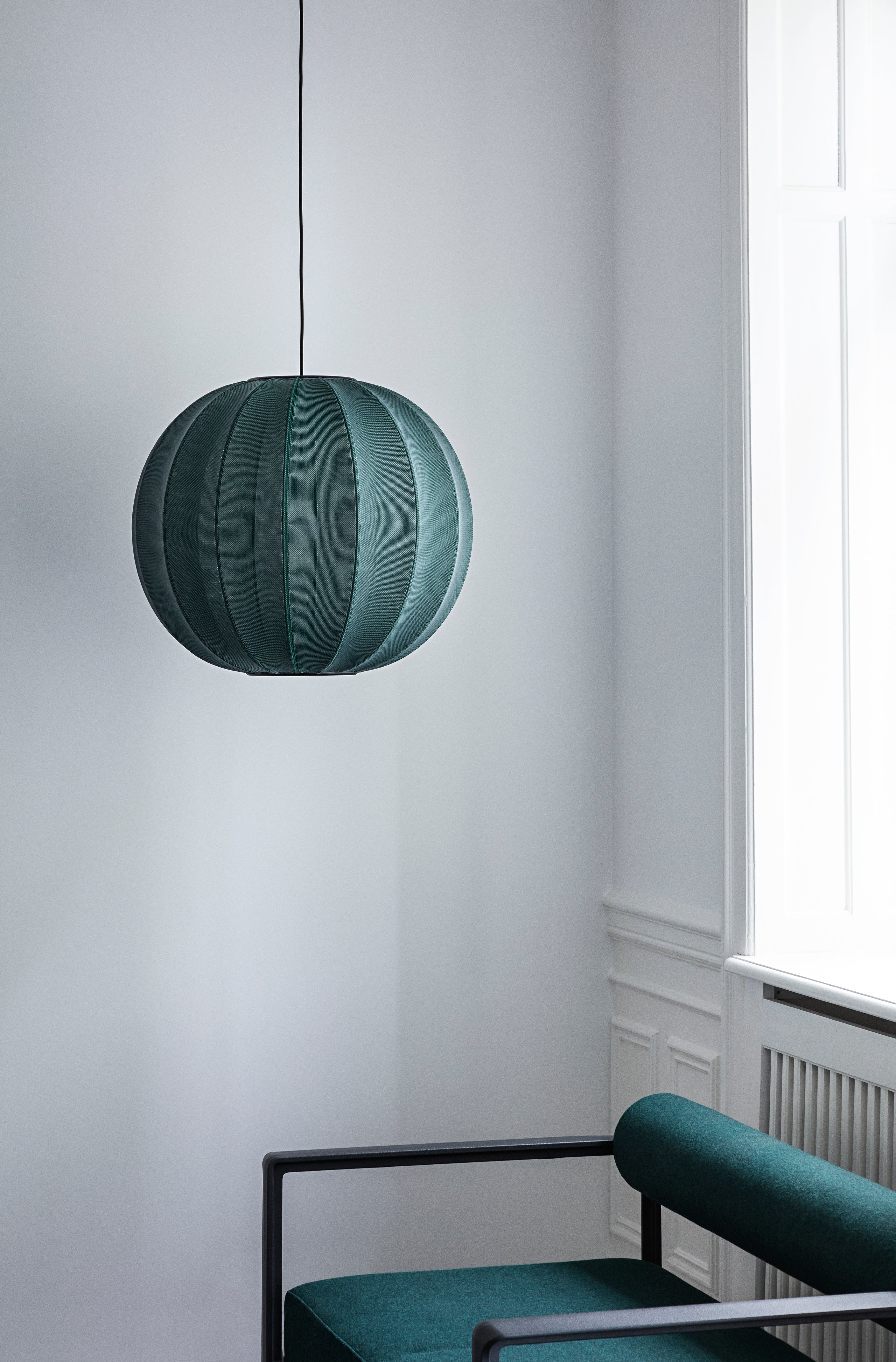 Den æstetiske designet Knit-Wit Ø45 Oval Loftslampe i Tweed Green hængt op i stuehjørnet