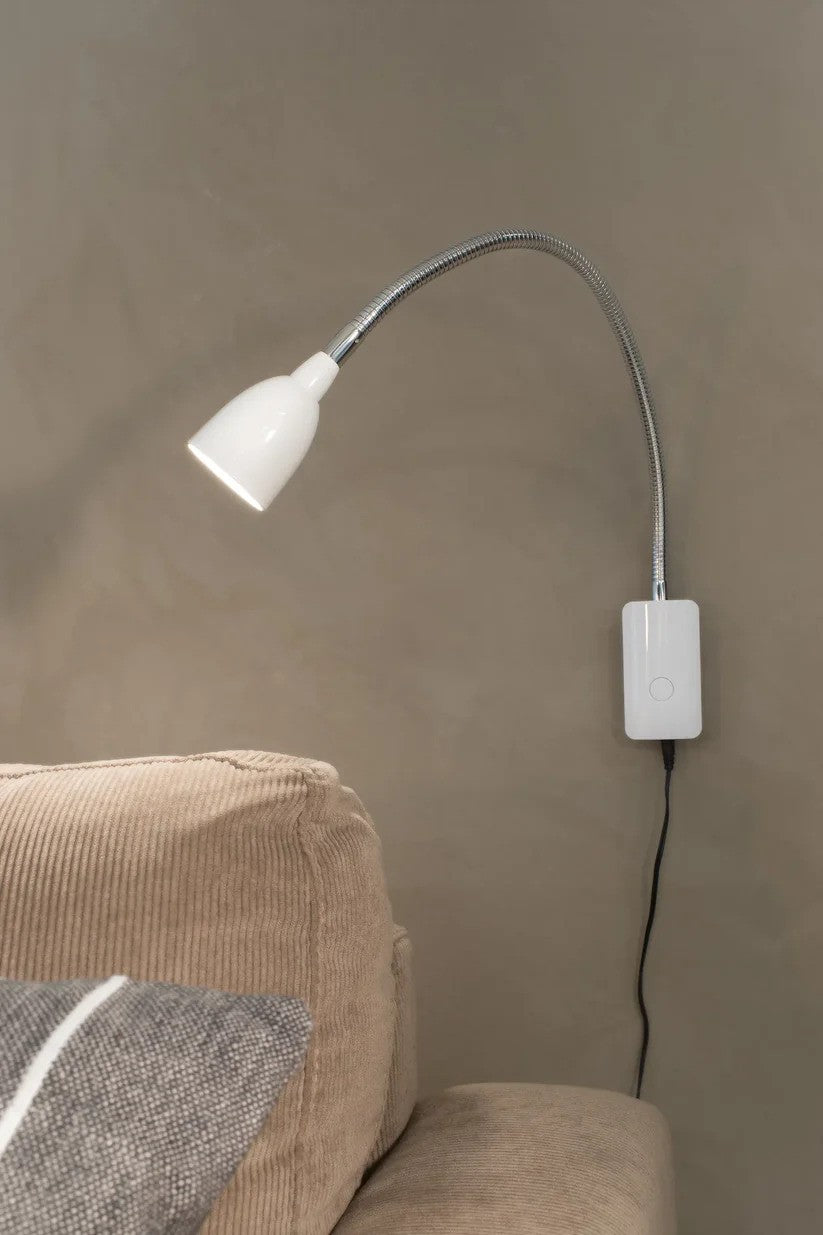 Markslöjd's Tulip Væglampe i Hvid hængt op ved siden af sofaen for den perfekte belysning til læsning