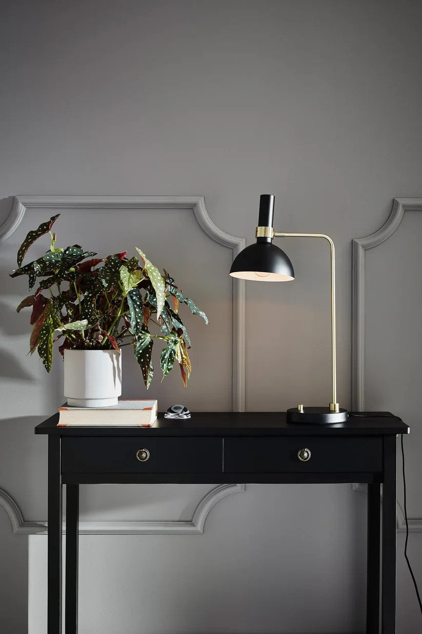 Markslöjd's elegante Larry Bordlampe 1L i Sort/Messing placeret på bordet i stuen