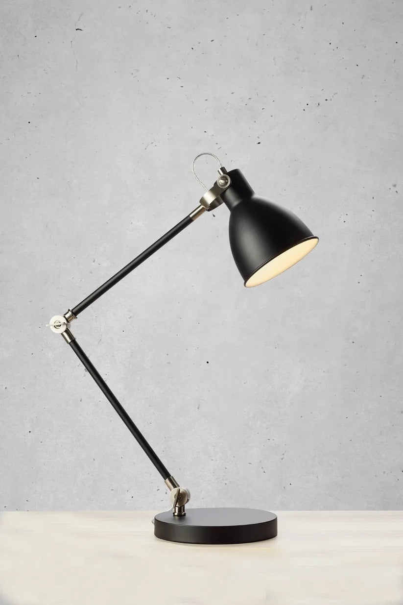 Zoomet helt ind på House Bordlampe 1L i Sort placeret på et bord med flot kontrast til væggen