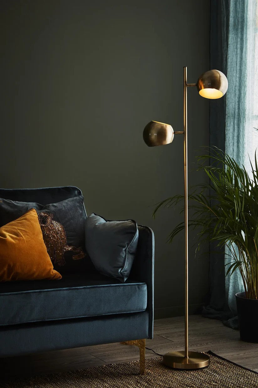 Den elegante gulvlampe fra Markslöjd Edgar Gulvlampe 2L i Antique placeret ved siden af sofaen