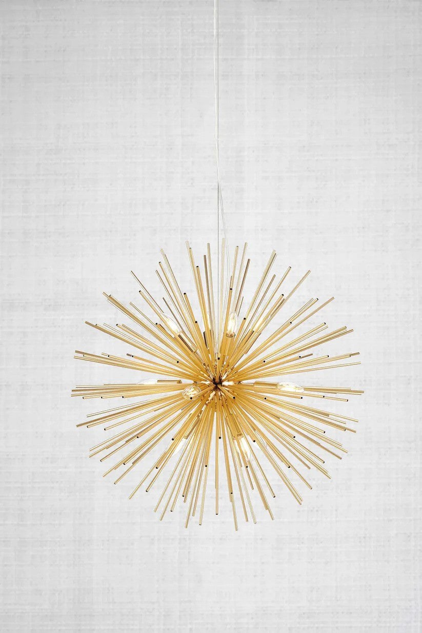 Den elegante Soleil Pendel 12L i Guld fra Markslöjd med den flotte kontrast til væggen