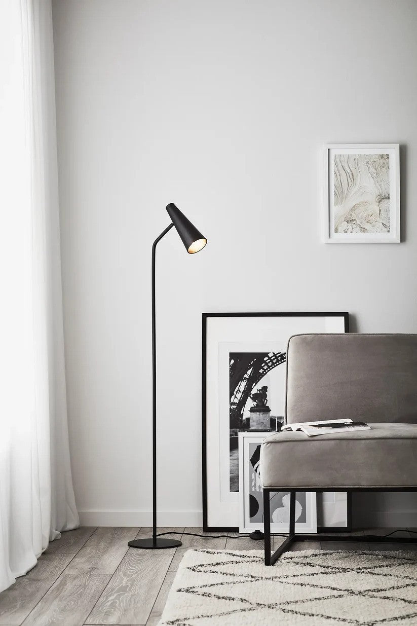 Markslöjd's Peak Gulvlampe i Sort placeret i hjørnet af stuen med det stilfulde design