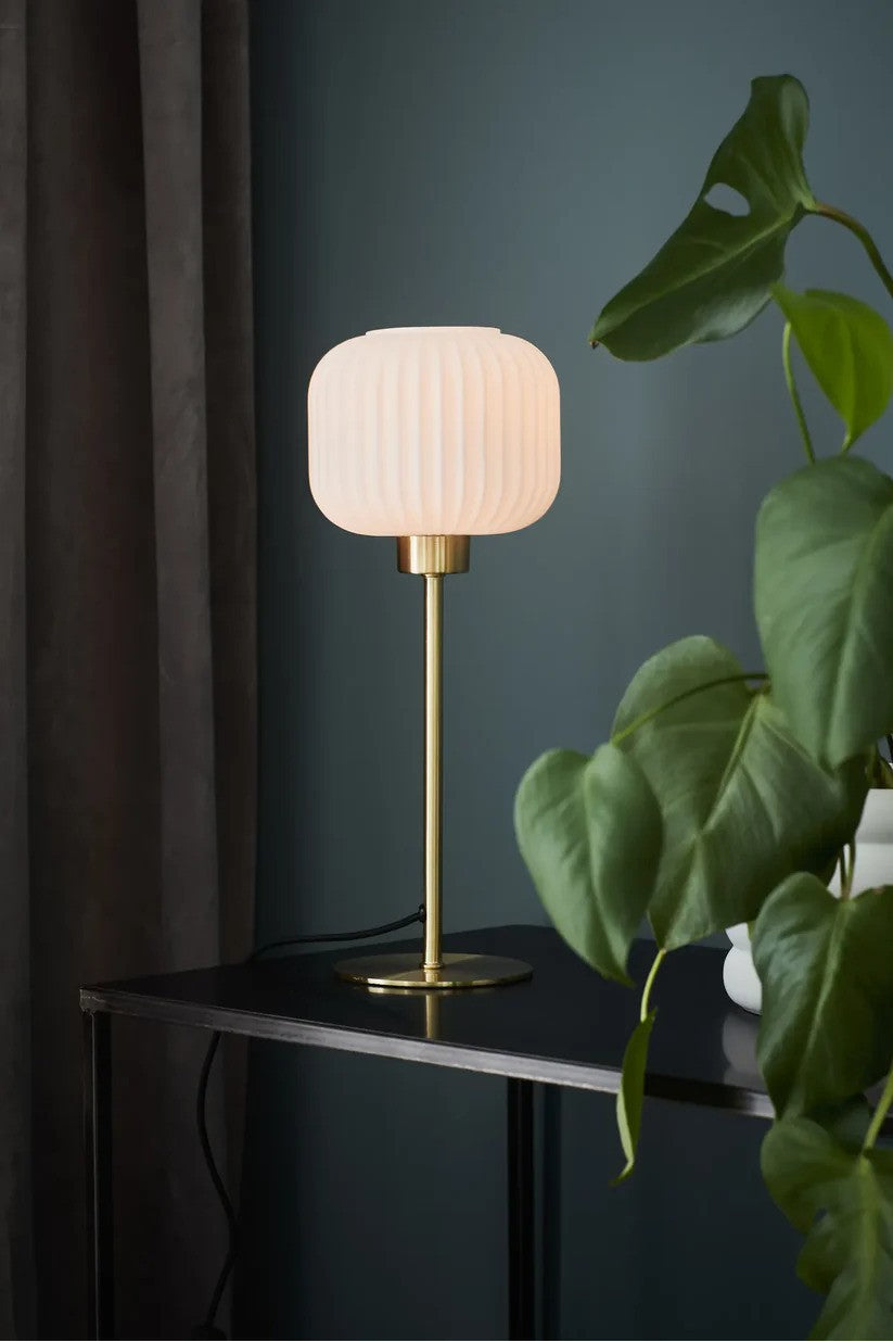 Den elegante og æstetiske bordlampe fra Markslöjd Sober Bordlampe 38 cm i Messing/Hvid sat på hylden for det behagelige lys