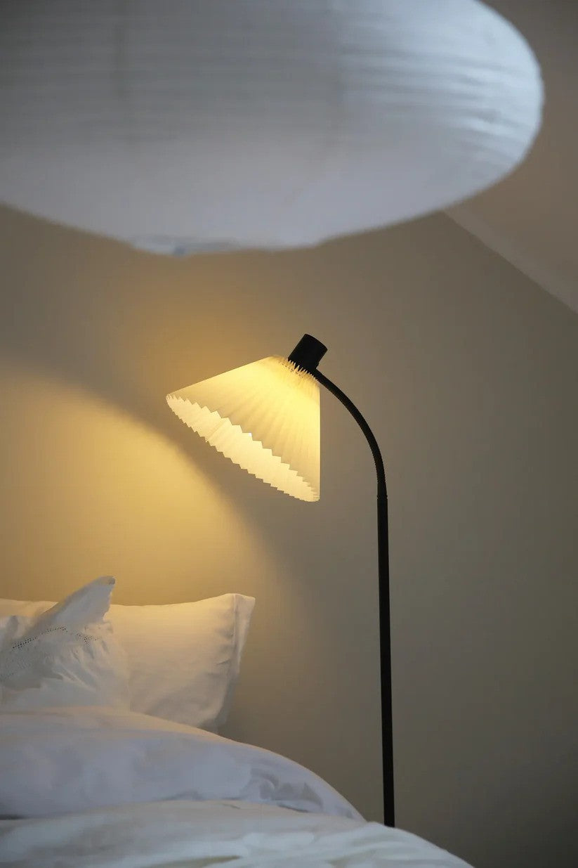 Mira Gulvlampe i Sort sat på kanten af sengen