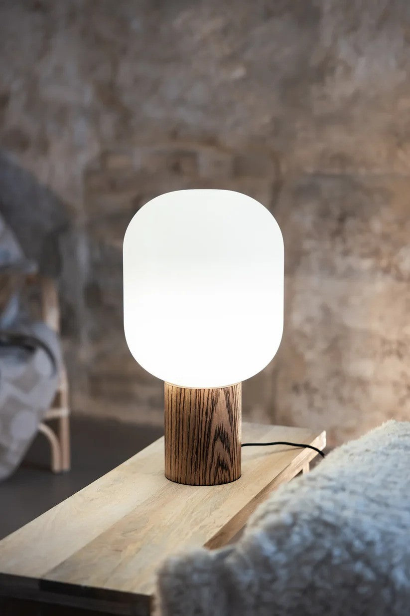 Skene Bordlampe i Træ sat på et bord i stuen for det hyggelige belysning