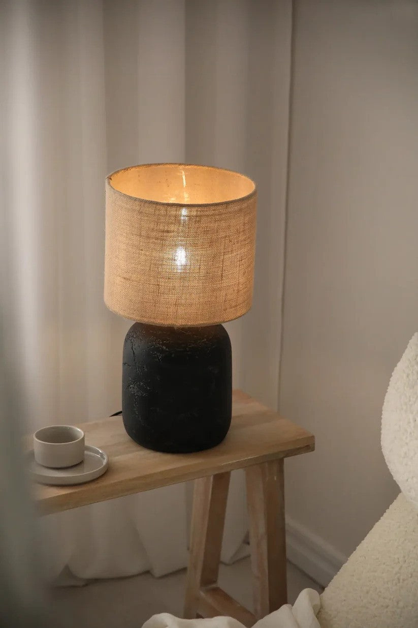 Motagna Bordlampe 45cm i Sort sat på en skammel i hjørnet af stuen for det behagelige belysning