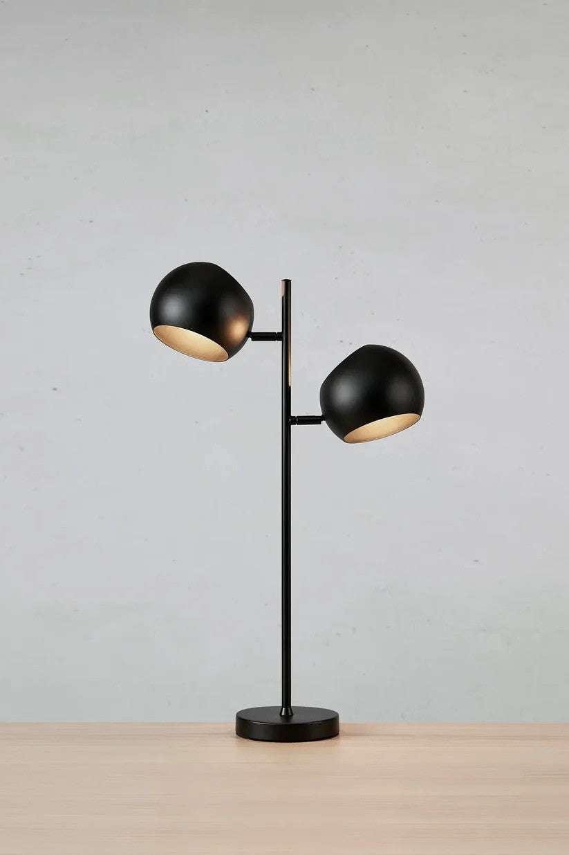 Edgar Bordlampe 2L i Sort sat på et bord foran en væg med en flot kontrast