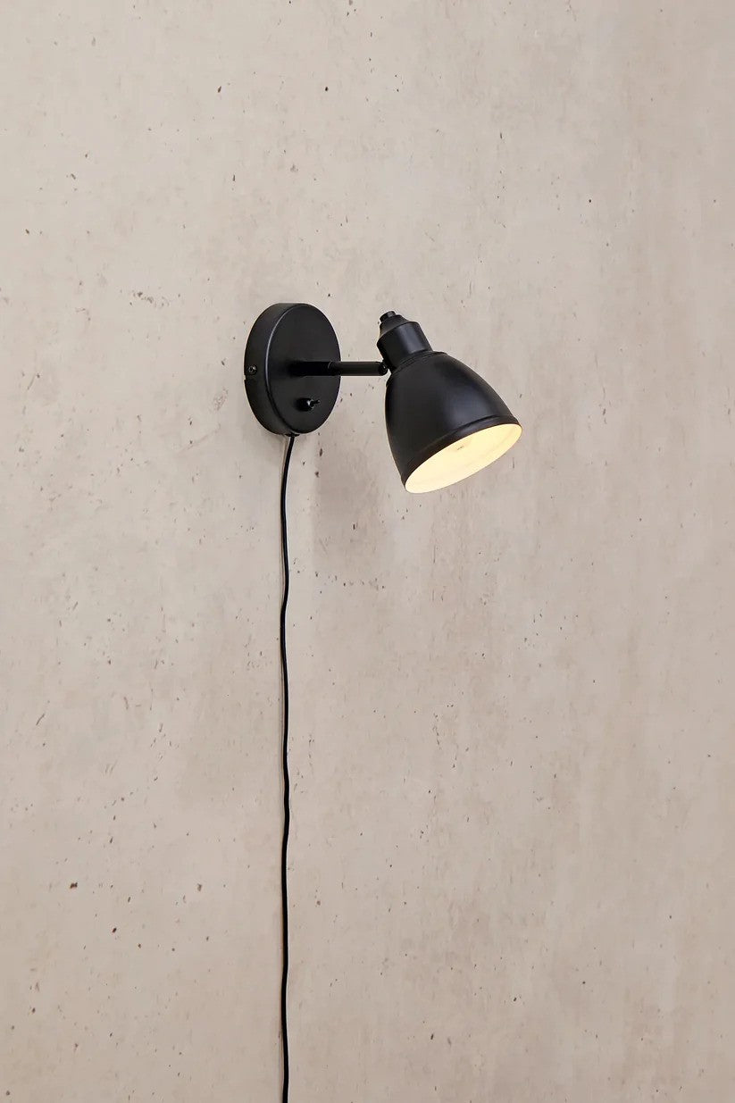 Den æstetiske lampe Story Væglampe i Sort hængt op på væggen for det behagelige belysning og flotte kontrast