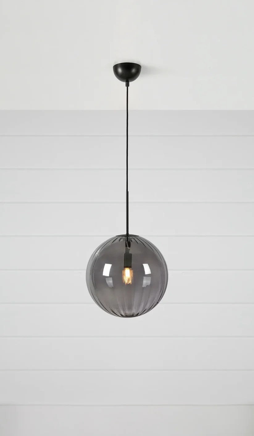 Den unikke og elegante Fengari Loftslampe i Mat Sort/Røg hængt op foran en væg med en flot kontrast