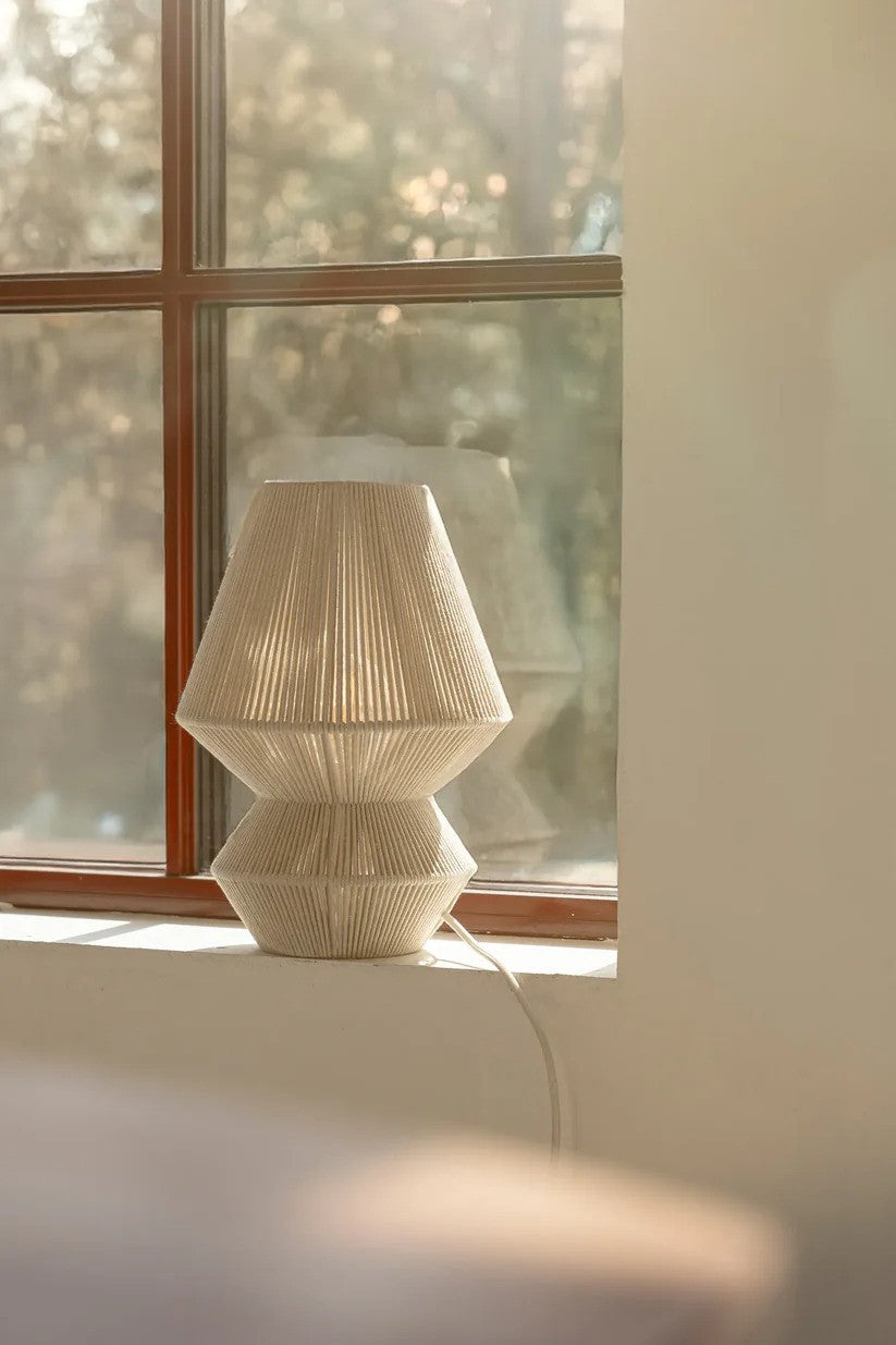 Den æstetiske Razzo Bordlampe 34cm i Beige stillet i vindueskammen