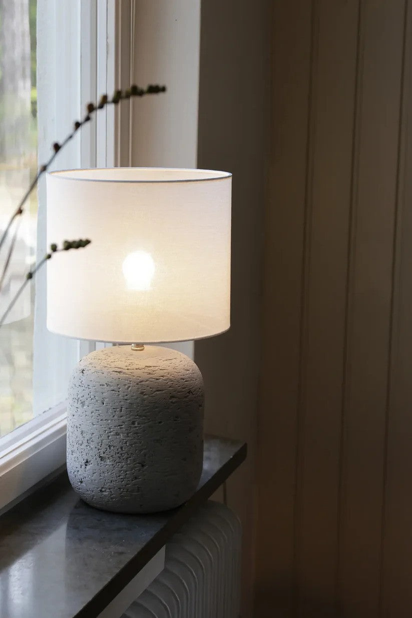 Den æstetiske Motagna Bordlampe 45cm i Grå stillet i vindueskammen med dens behagelige belysning