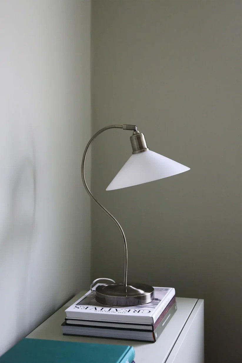 Den æstetiske Vela Bordlampe i Hvid placeret på skuffen for dens behagelige belysning