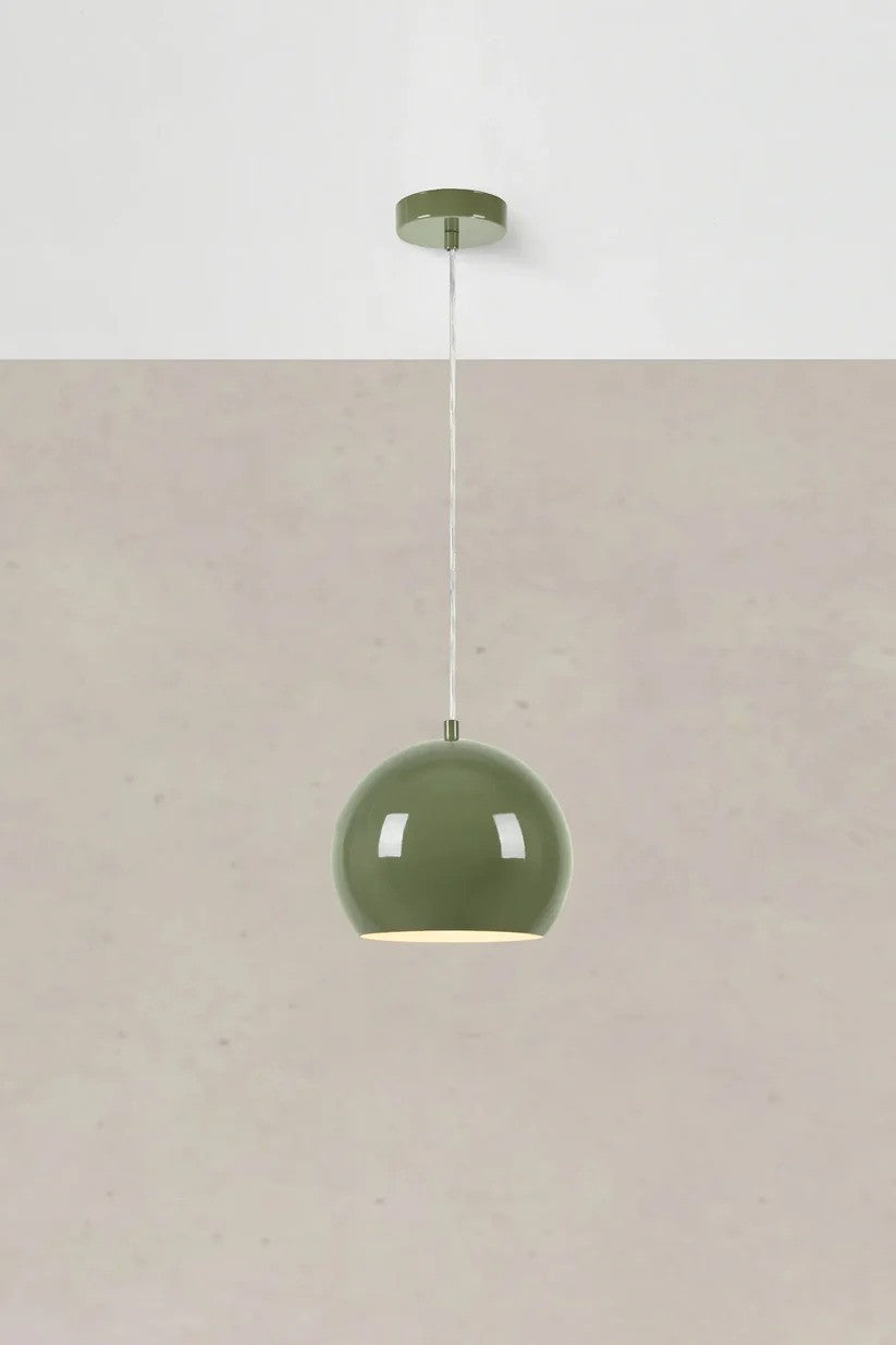 Den stilrene designet Pop Pendel 20cm i Grøn hængt op foran en væg for en flot kontrast