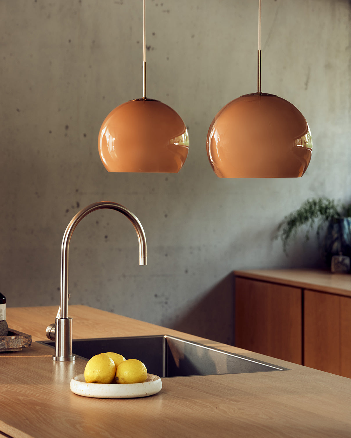 2 af de æstetiske designet Ball Glass Pendel Ø25 i Cappuccino hængt op i køkkenet for deres varme belysning