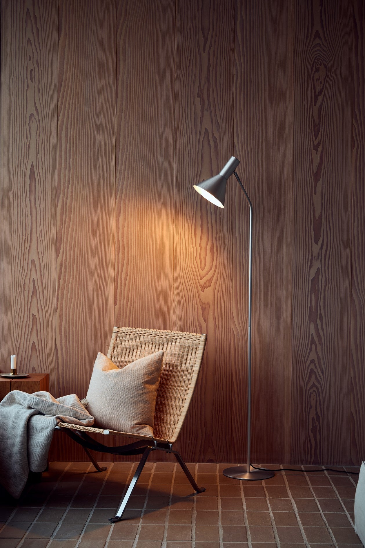 Den æstetiske Lyss Gulvlampe i Brushed Aluminium placeret i hjørnet af stuen for dens behagelige belysning