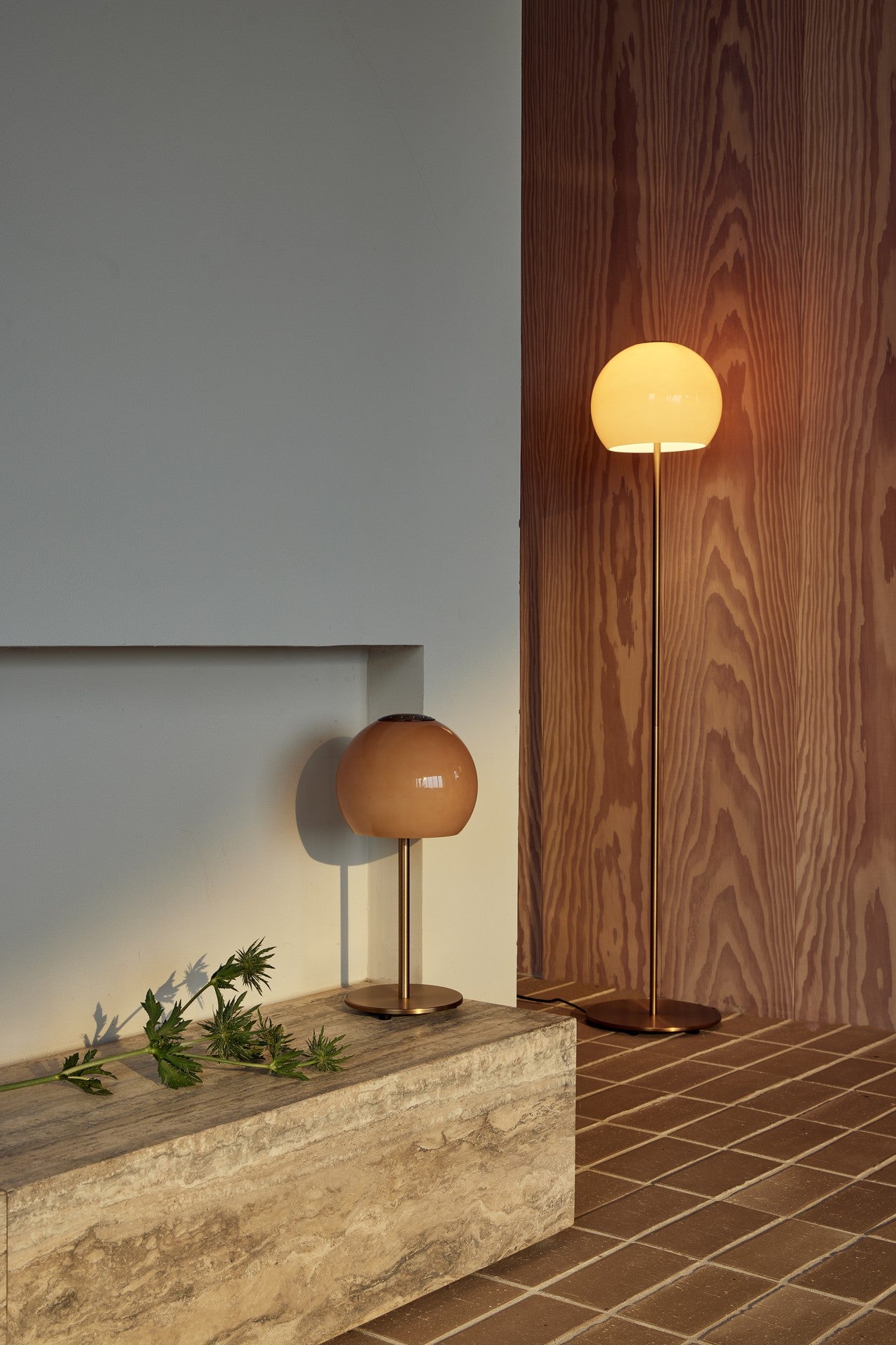 Den elegante designet Frandsen Ball Glass Bordlampe Ø18 i Amber placeret i stuen for dens varme belysning
