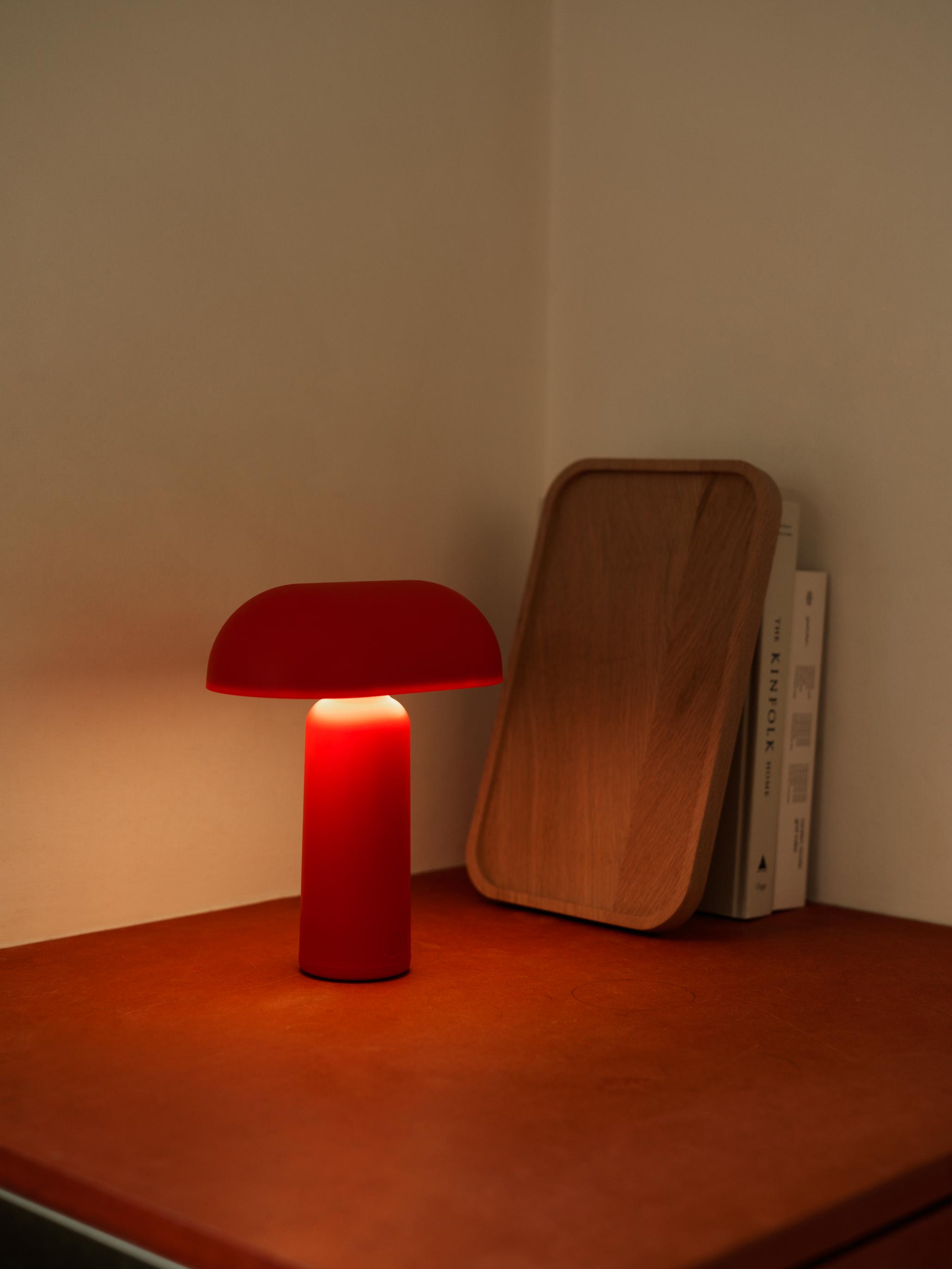 Nyd den hyggeligt røde Porta bordlampe fra Normann Copenhagen i ethvert regi