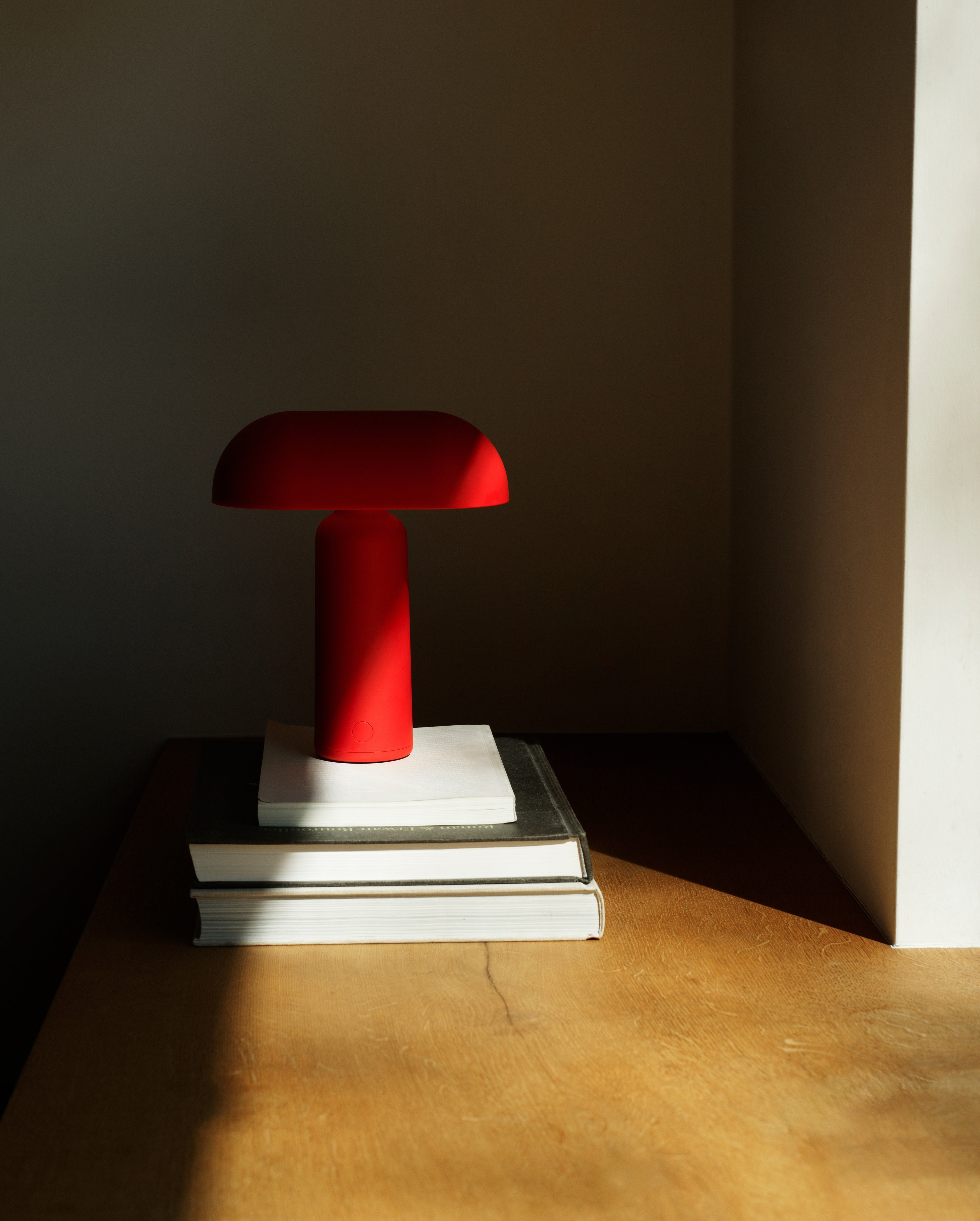 Porta rød portable bordlampe halvt i lyset