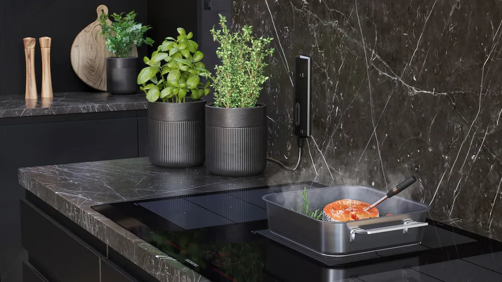 Den æstetiske Siemens HZ32WA00 Trådløst stegetermometer placeret i noget kød der steger for dens præcise måling